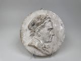 an image of a white marble medallion with a man ' s face