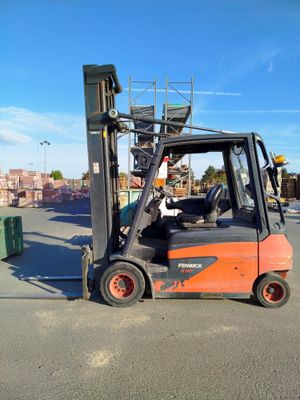 a forklift that is sitting in the middle of a parking lot