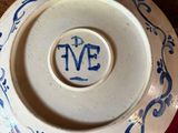 a blue and white plate with a monogram on it