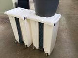 une poubelle posée sur un radiateur, à côté d'une autre poubelle