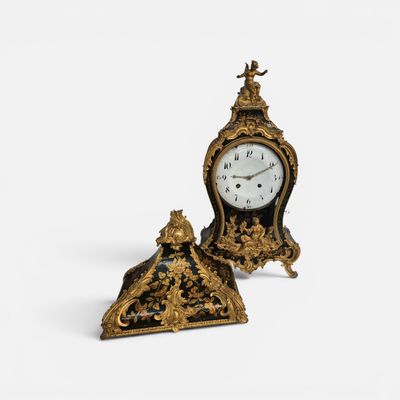 une petite horloge posée à côté d'une autre horloge, encore plus petite