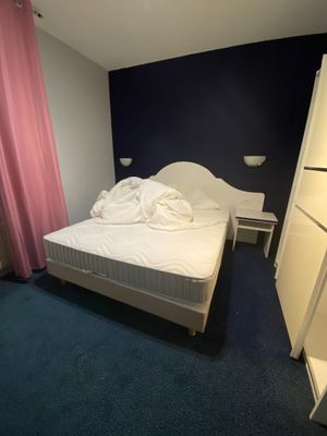 a white bed in a room with a blue wall