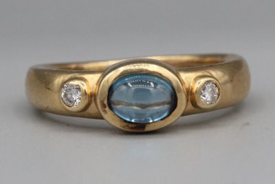 Gros plan sur une bague en or ornée d'une topaze bleue