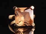 un gros plan d'une bague sertie d'une topaze orange