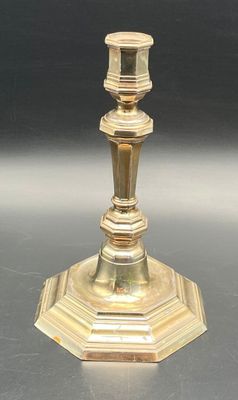 a gold candle holder on a table with a black background