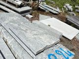un tas de granit posé par terre à côté d'un tas de parpaings