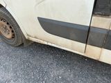 a dirty white van parked on the side of the road
