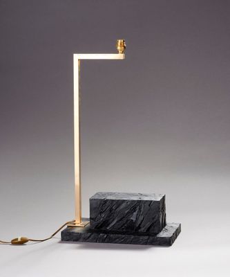 une image représentant une lampe en marbre noir avec un pied doré