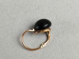 a close up of a gold ring with a black stone on it