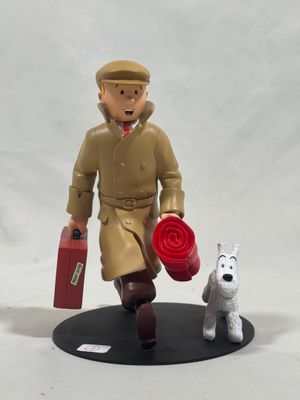 a figurine of a man with a suitcase and a dog