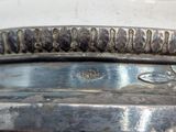 a silver vase with a bird on it on a table