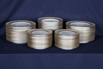 plusieurs piles d'assiettes en argent posées sur une table recouverte d'une nappe bleue