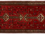 un tapis rouge orné d'un motif en losanges sur fond blanc