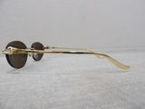 gold rimmed sunglasses with brown lenses on a white background