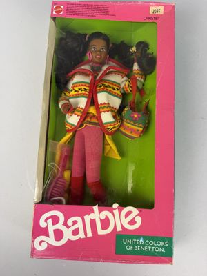 poupée Barbie dans sa boîte, avec ses vêtements et ses accessoires, posée sur une surface blanche