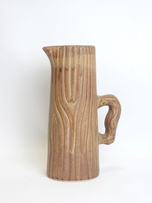 a brown pitcher that is sitting on a white surface