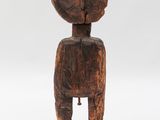 a wooden statue of a person with a head on a base