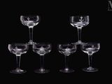 six verres à vin vides empilés les uns sur les autres sur une surface noire