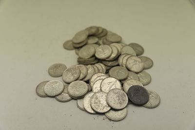 une pile de pièces d'argent posée sur un comptoir blanc