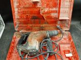 une mallette à outils rouge contenant une perceuse