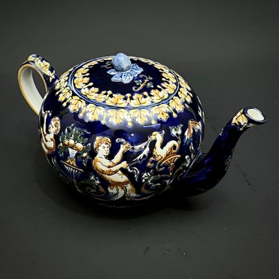 a blue teapot with a gold and blue design on it
