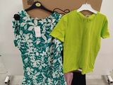 two shirts are hanging on a rack in front of a cardboard box