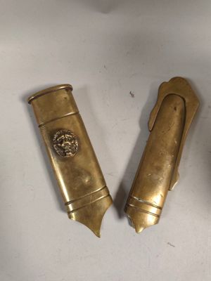 deux briquets en laiton posés l'un à côté de l'autre sur une table