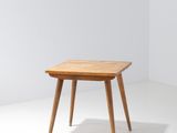 une petite table avec un plateau en bois sur un sol blanc