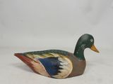 a wooden duck that is sitting on a white surface