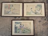 Trois tableaux asiatiques encadrés sont accrochés au mur d'une pièce