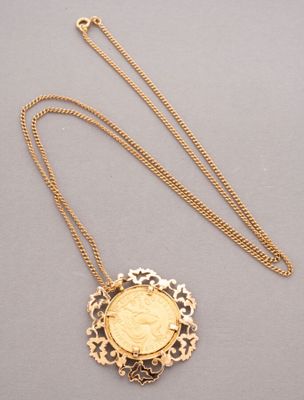 a gold necklace with a coin in the middle of it