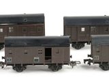 six miniature train cars are lined up in a row on a white surface