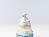 un petit vase blanc et bleu posé sur une table