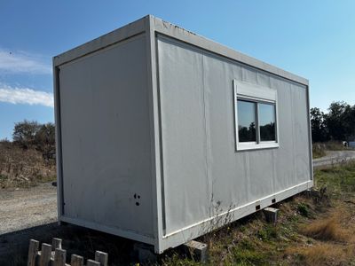 a small white building sitting on the side of the road