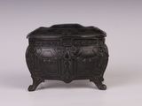 une boîte ancienne en métal noir ornée de sculptures élaborées