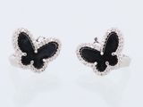 une paire de boucles d'oreilles en forme de papillons noirs et blancs sur un fond blanc