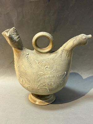 a white vase that has a handle on it