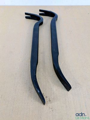 une paire de poignées en plastique noir sur une surface en bois