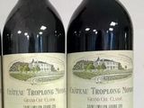 three bottles of red wine are lined up on a table