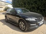 the black jaguar suv is parked in front of a building