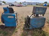 two blue machines that are sitting in the grass