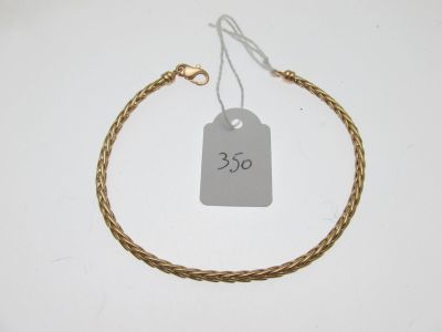 gros plan d'un bracelet en or portant une étiquette de prix
