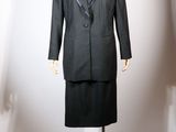 un mannequin vêtu d'un tailleur noir et d'une jupe, exposé