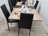 a wooden table with black chairs in a small room