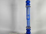 une lampe bleue surmontée d'un cordon blanc