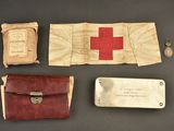 an old medical kit with a red cross on it next to other items