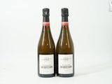deux bouteilles de vin posées l'une à côté de l'autre sur une surface blanche