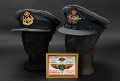 une paire de casquettes militaires exposées sur un fond noir