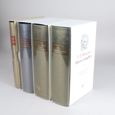 three books sitting on top of each other on a white surface