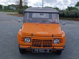 un camion orange garé sur un parking